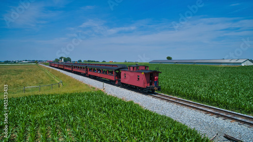 Obraz na plátne Aerial View of Thomas the Tank Engine Approaching Thru Trees and Farmlands Pulli
