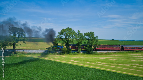 Foto Aerial View of Thomas the Tank Engine Approaching Thru Trees and Farmlands Pulli