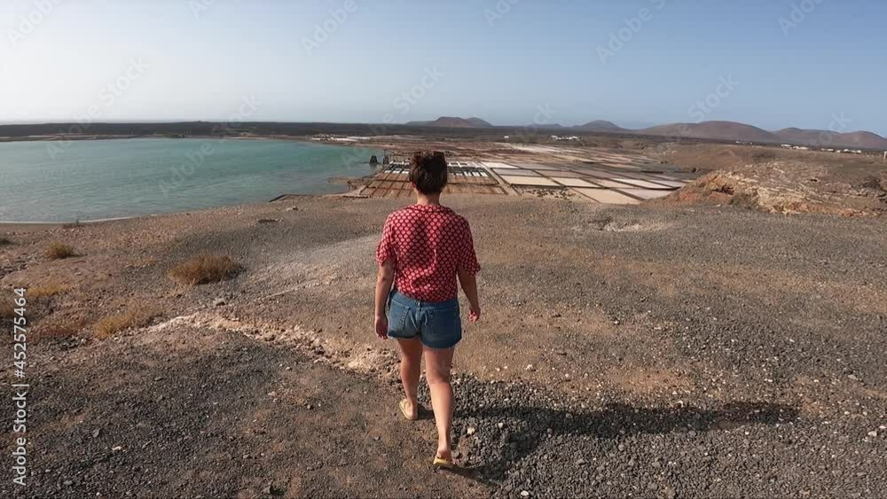 girl walking in Las Salinas de Janubio, sea salt lakes in Lanzarote, Canary Islands, in Spain girl walking in Las Salinas de Janubio, sea salt lakes in Lanzarote, Canary Islands, in Spain