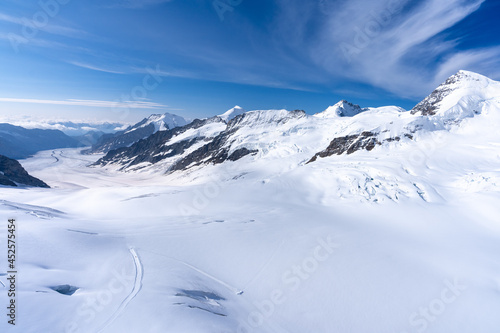 des montagnes enneigées sous un ciel bleu au bords d'un glacier