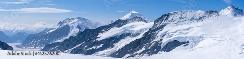 vue panoramique sur une chaine de montagne enneigées sous un ciel bleu