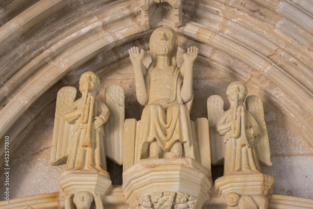 Portal entrance to medieval church on Camino de Santiago, Spain. Three saint statues at cathedral facade. Pilgrimage concept. Church facade with small sculptures. Religious architecture.