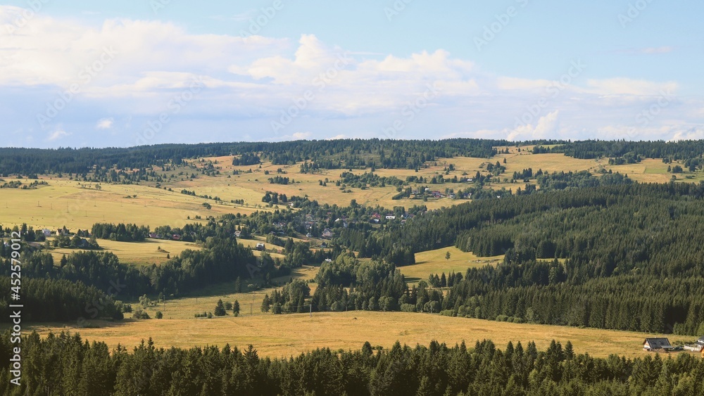 Fototapeta premium A view to the landscape full of meadows and trees from the top of the mountain Plessberg, Czech republic