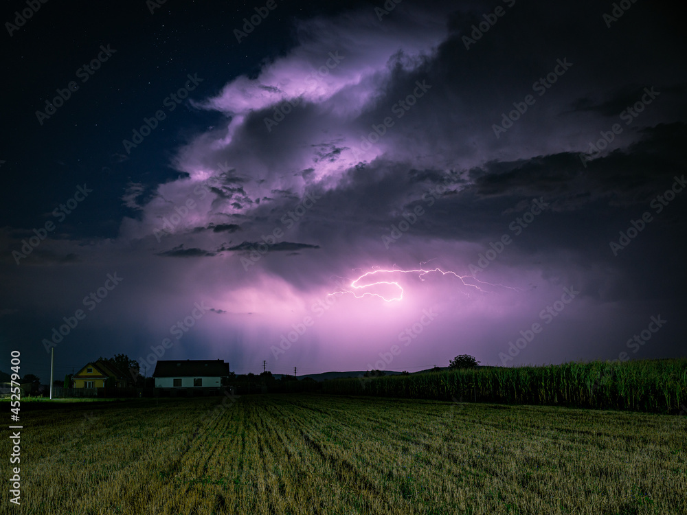 Fototapeta premium Majestic Cumulonimbus storm cloud is lit by lightning at night