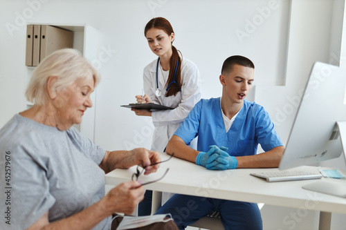 a nurse and a doctor communicate with an elderly woman patient hospital health care