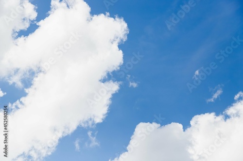 White fluffy clouds in a clear light blue sky, copy space