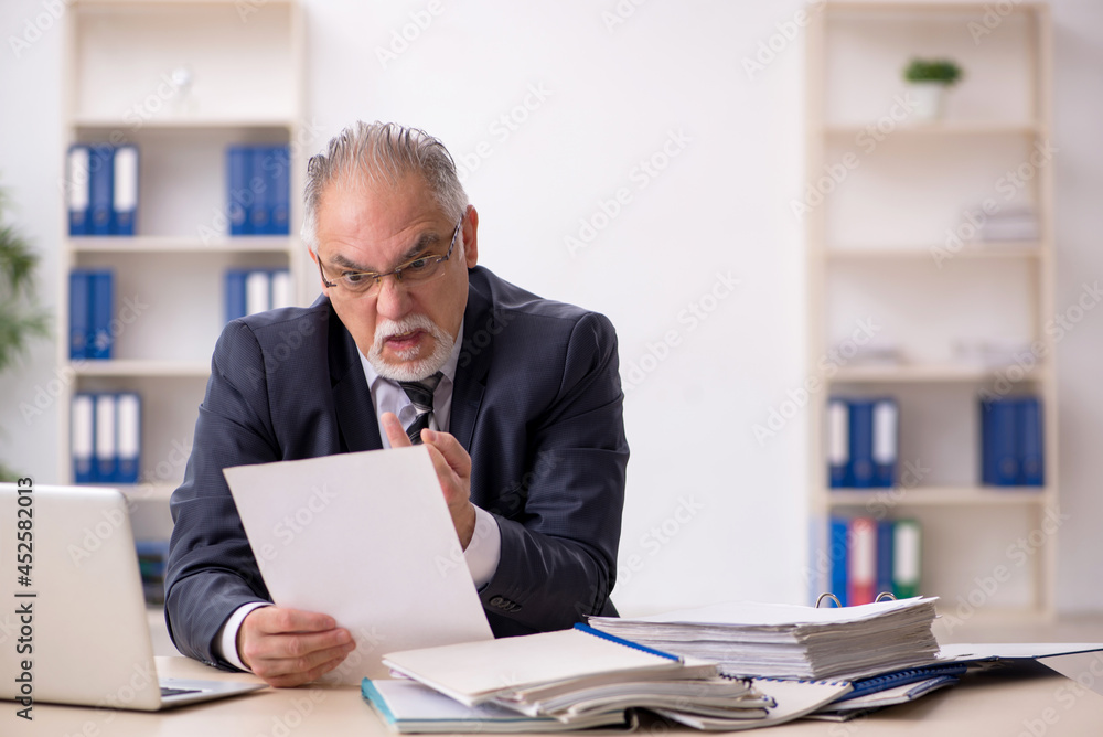 Old male employee working in the office Old male employee working in the office
