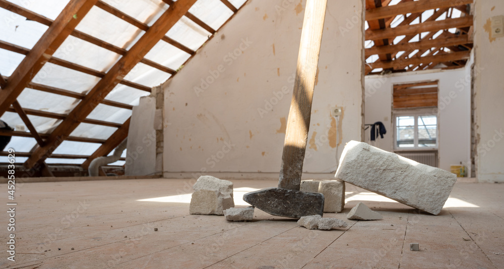 Renovating the attic of a private house. A sledge hammer and some bricks lie on the floor. Renovating the attic of a private house. A sledge hammer and some bricks lie on the floor.