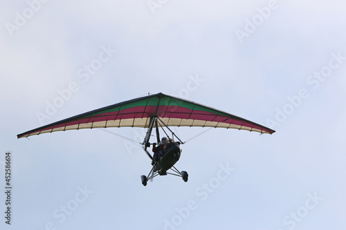 	
Ultralight airplane flying in a blue sky	