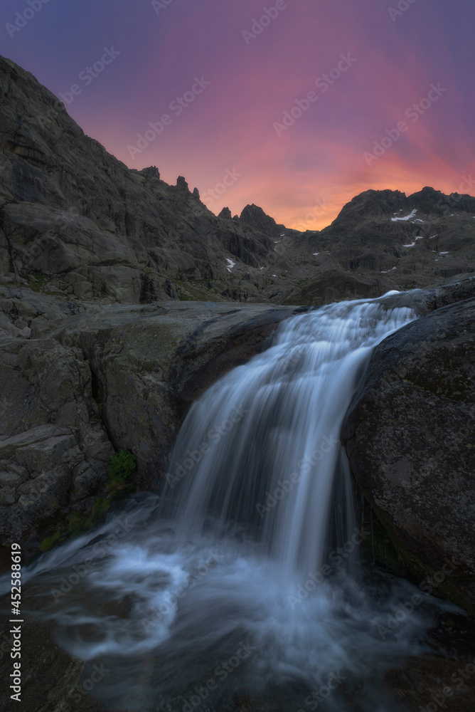 Fast waterfall on ridge under sunset sky Fast waterfall on ridge under sunset sky