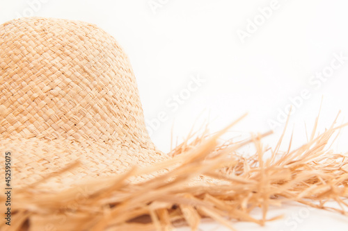 Beautiful straw hat with with ragged edges on white background, style and fashion