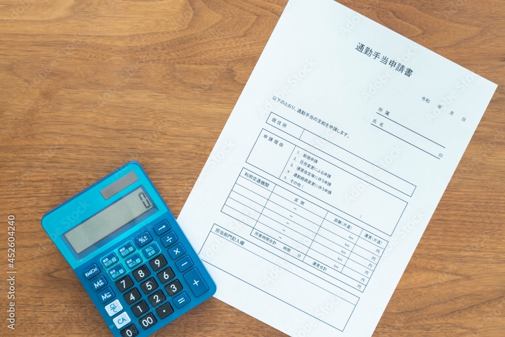 自宅と会社の間の通勤代を申請する通勤手当申請書と金額を計算する電卓 自宅と会社の間の通勤代を申請する通勤手当申請書と金額を計算する電卓