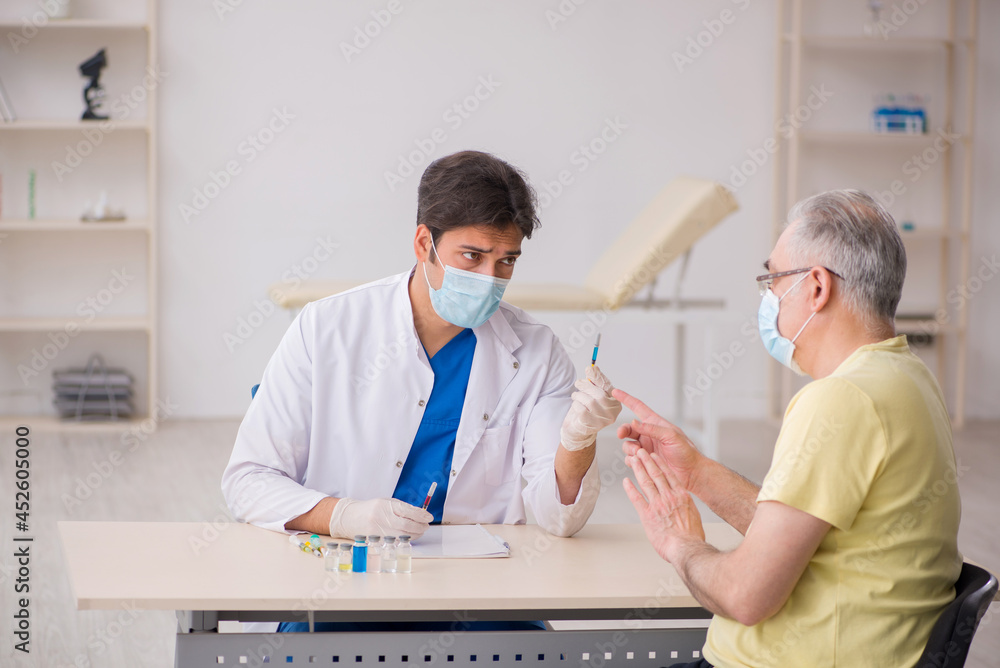 Obraz premium Old male patient visting young male doctor in vaccination concep
