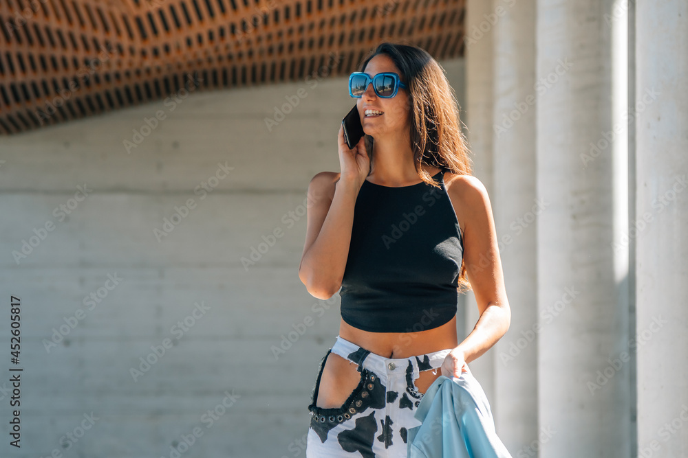 girl talking on mobile phone on the street at sunset girl talking on mobile phone on the street at sunset