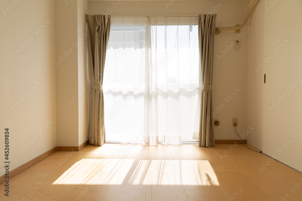 sunlight coming inside empty room with white wall and wooden bwon floor in tokyo, japan sunlight coming inside empty room with white wall and wooden bwon floor in tokyo, japan