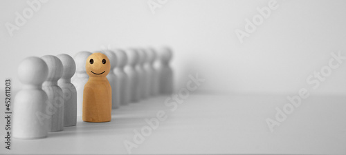 red figurine of a man stands aside from the crowd of people. Asociality, sociopathy. photo