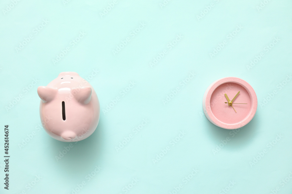 Alarm clock with piggy bank on color background Alarm clock with piggy bank on color background