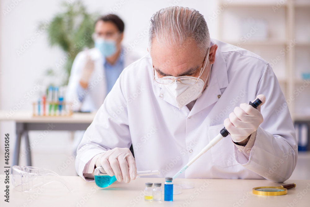Two male chemists working at the lab during pandemic Two male chemists working at the lab during pandemic