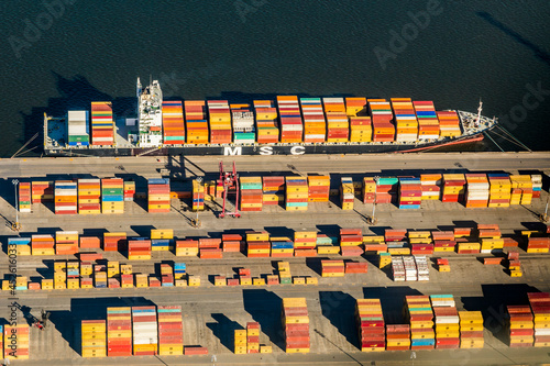 Aerial top view of business logistic import and export freight transportation by container ship in St-Lawrence River, Montreal, Quebec, Canada