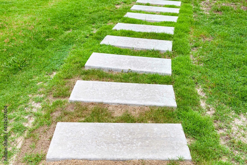 White granite walkway slabs patterned in green lawns at the garden White granite walkway slabs patterned in green lawns at the garden