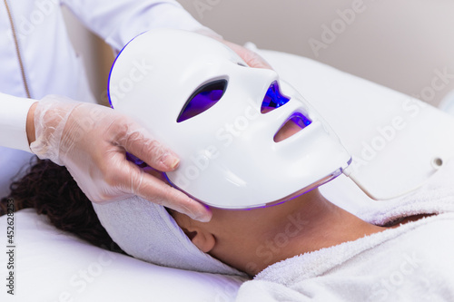 Photodynamic therapy facial mask on woman's face photo
