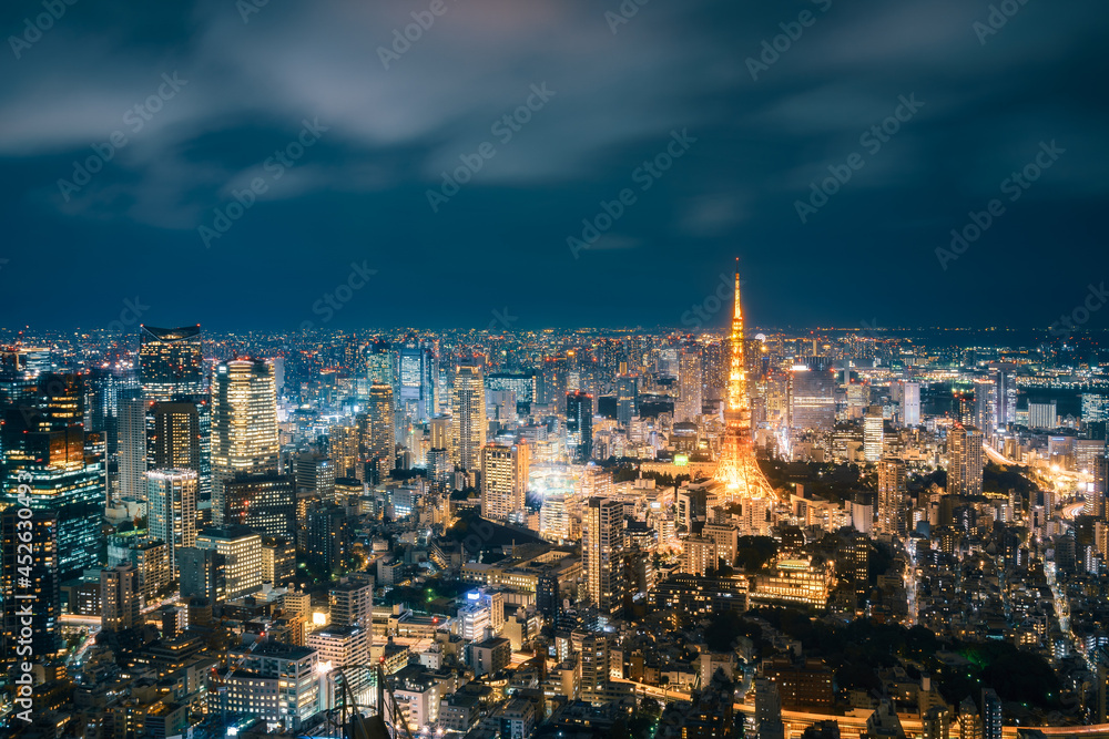 Long exposure Panoramic View from above of modern Tokyo Metropolis illuminated at night with Tokyo Tower and light trails on the streets below in Tokyo, Japan. Long exposure Panoramic View from above of modern Tokyo Metropolis illuminated at night with Tokyo Tower and light trails on the streets below in Tokyo, Japan.
