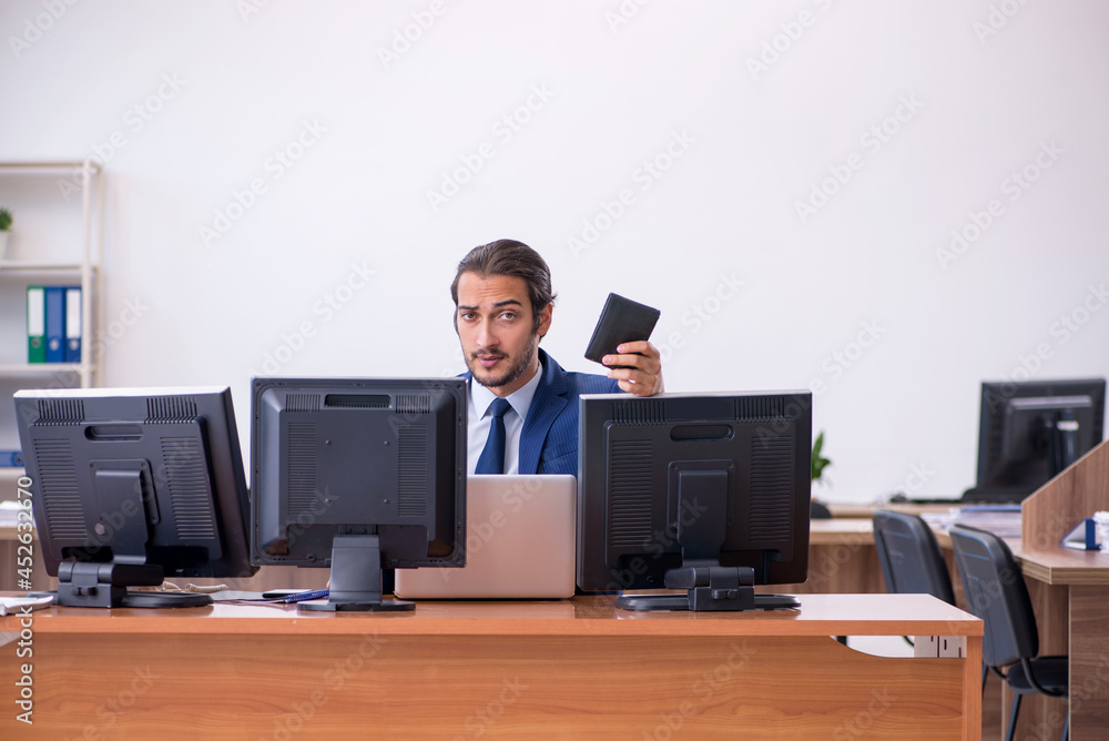 Young male employee in multitasking concept Young male employee in multitasking concept