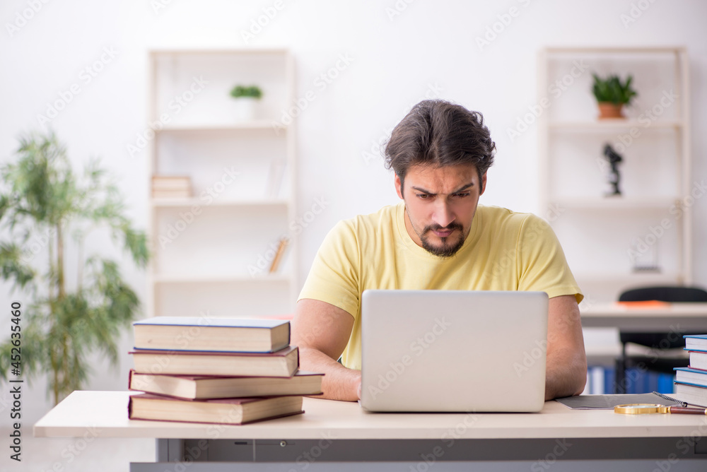 Young male student in telestudying concept Young male student in telestudying concept