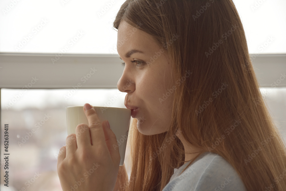 Faceless woman drinking tea in room Faceless woman drinking tea in room