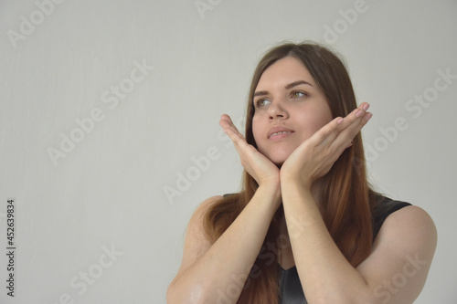 Beautiful woman with palms under chin