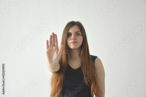 Serious woman outstretching hand on white background