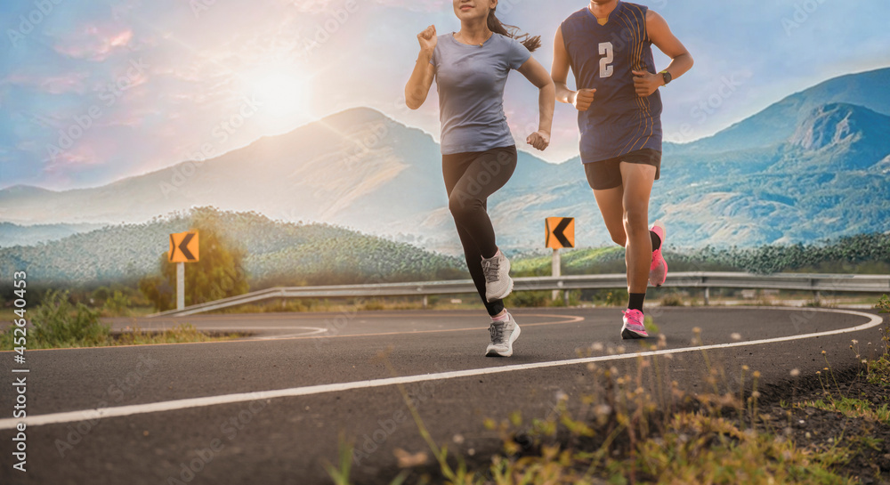 Φωτογραφία young couple runner running on running road in city park with mountains in the background