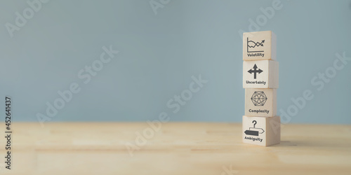 Strategic management and VUCA concept. Wood cube VUCA icon and text; volatility, uncertainty, complexity, ambiguity with grey background. The modern management for new trend and rapid transition.