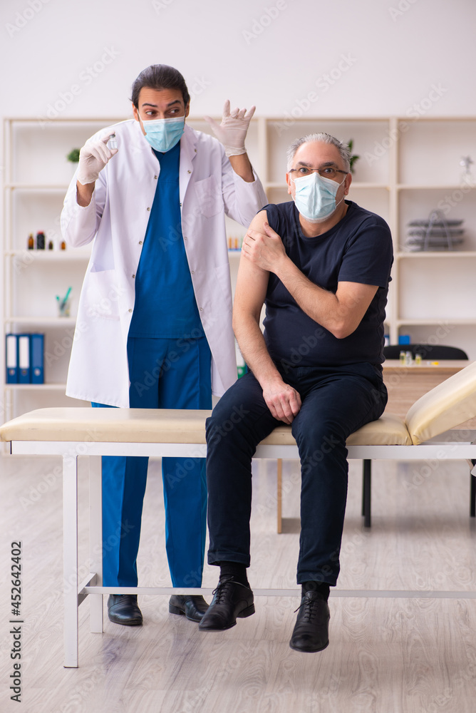 Old man visiting young doctor in covid-19 vaccination concept Old man visiting young doctor in covid-19 vaccination concept