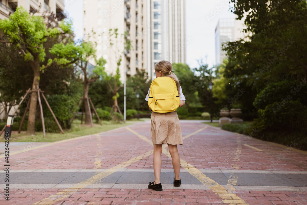 Schoolgirl back to school after summer vacations. Child in uniform smiling early morning outdoor. Schoolgirl back to school after summer vacations. Child in uniform smiling early morning outdoor.