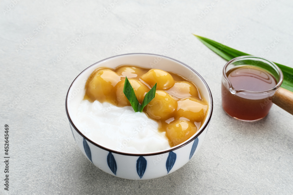 Bubur candil or kolak biji salak, Indonesian traditional food made from sticky rice flour, brown sugar and coconut milk. Popular during ramadan. Served in white bowl on grey background. Close up.
Bubur candil or kolak biji salak, Indonesian traditional food made from sticky rice flour, brown sugar and coconut milk. Popular during ramadan. Served in white bowl on grey background. Close up.