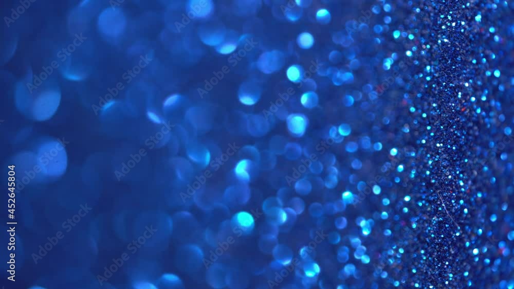 Blue Glitter Background. Magic dust, shiny texture, holiday lights, flying particles form a beautiful bokeh. Shining festive Christmas backdrop. Vertical Video Blue Glitter Background. Magic dust, shiny texture, holiday lights, flying particles form a beautiful bokeh. Shining festive Christmas backdrop. Vertical Video