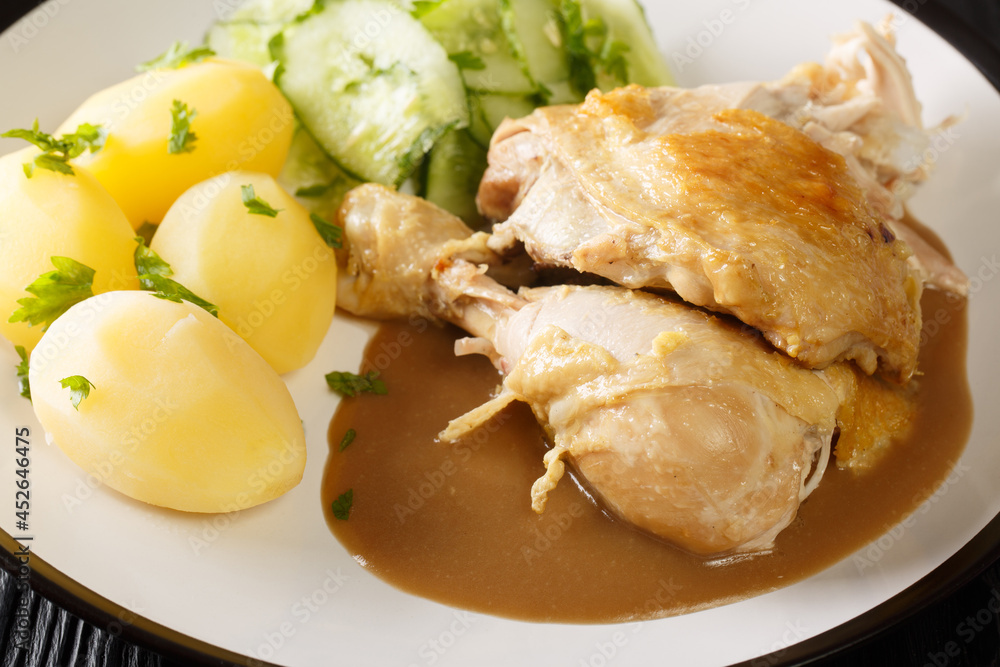 Gammeldags Kylling traditional Chicken Dish From Denmark with potatoes, cucumber salad, and sauce closeup in the plate on the table. Horizontal Gammeldags Kylling traditional Chicken Dish From Denmark with potatoes, cucumber salad, and sauce closeup in the plate on the table. Horizontal