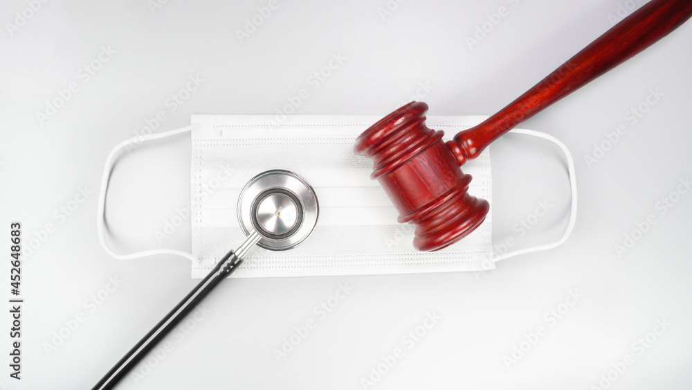 Medical lawsuit concept with stethoscope, mask and judge gavel. Corona virus self-quarantine, etc. Top view. Medical lawsuit concept with stethoscope, mask and judge gavel. Corona virus self-quarantine, etc. Top view.