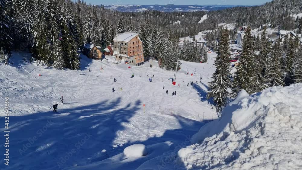 People skiing and snowboarding on snow slope in winter ski resort. Ski elevator on snow mountain. Winter activity and great weather with sunshine People skiing and snowboarding on snow slope in winter ski resort. Ski elevator on snow mountain. Winter activity and great weather with sunshine