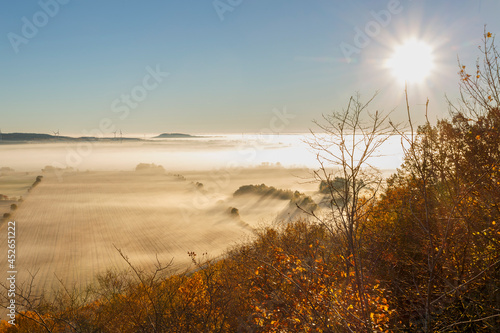 Fototapeta Naklejka Na Ścianę i Meble -  Morning fog with sun rays over the landscape in the fall