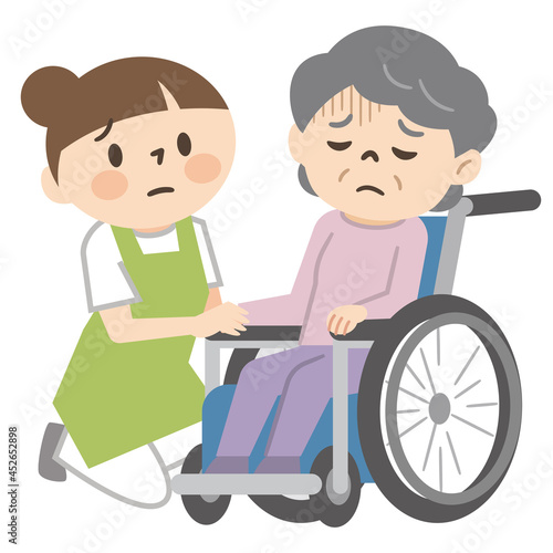 落ち込んだ感情の車椅子に乗ったシニア女性と寄り添う女性介護士