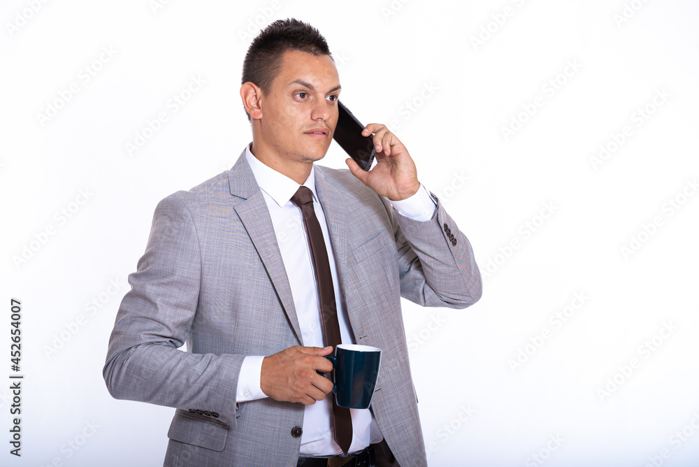 a young handsome businessman in a suit with a cup of coffee a young handsome businessman in a suit with a cup of coffee