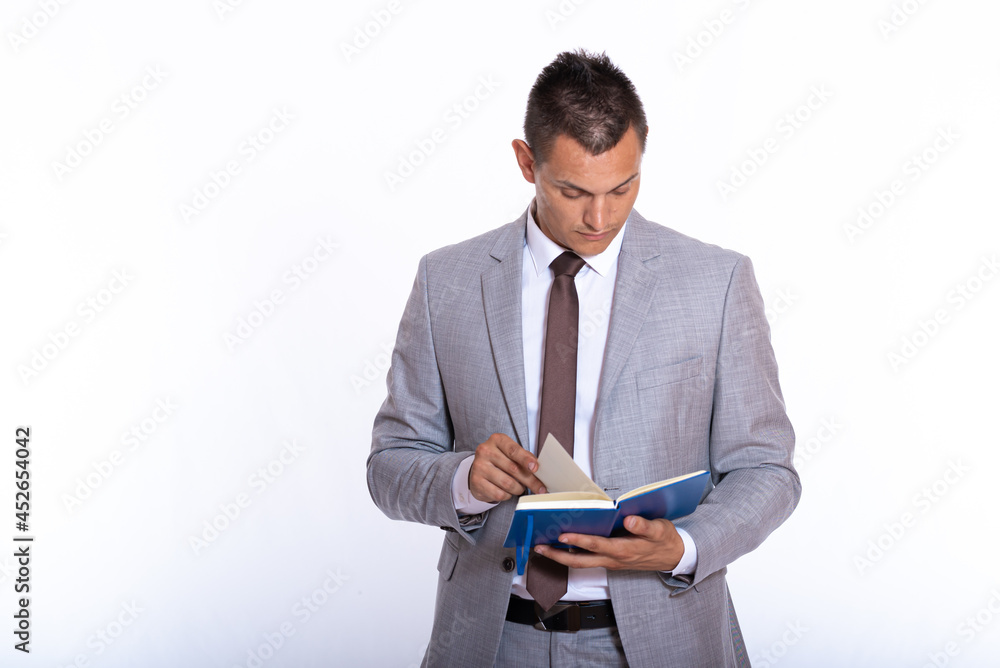 a young handsome businessman in a suit with a notebook