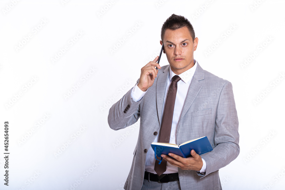 a young handsome businessman in a suit with a notebook a young handsome businessman in a suit with a notebook