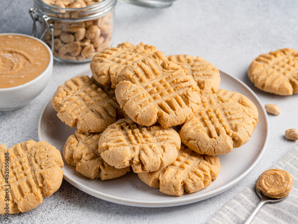 Peanut butter cookies stacked on ceramic plate. Close up view. Traditional american dessert, snack, dessert or breakfast food. Biscuits made of homemade nut butter, sugar, eggs and flour. Peanut butter cookies stacked on ceramic plate. Close up view. Traditional american dessert, snack, dessert or breakfast food. Biscuits made of homemade nut butter, sugar, eggs and flour.
