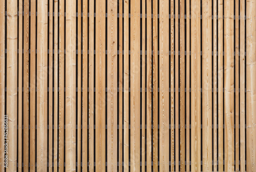 Background modern facade or ceiling made of larch wood strips in the outdoor photo