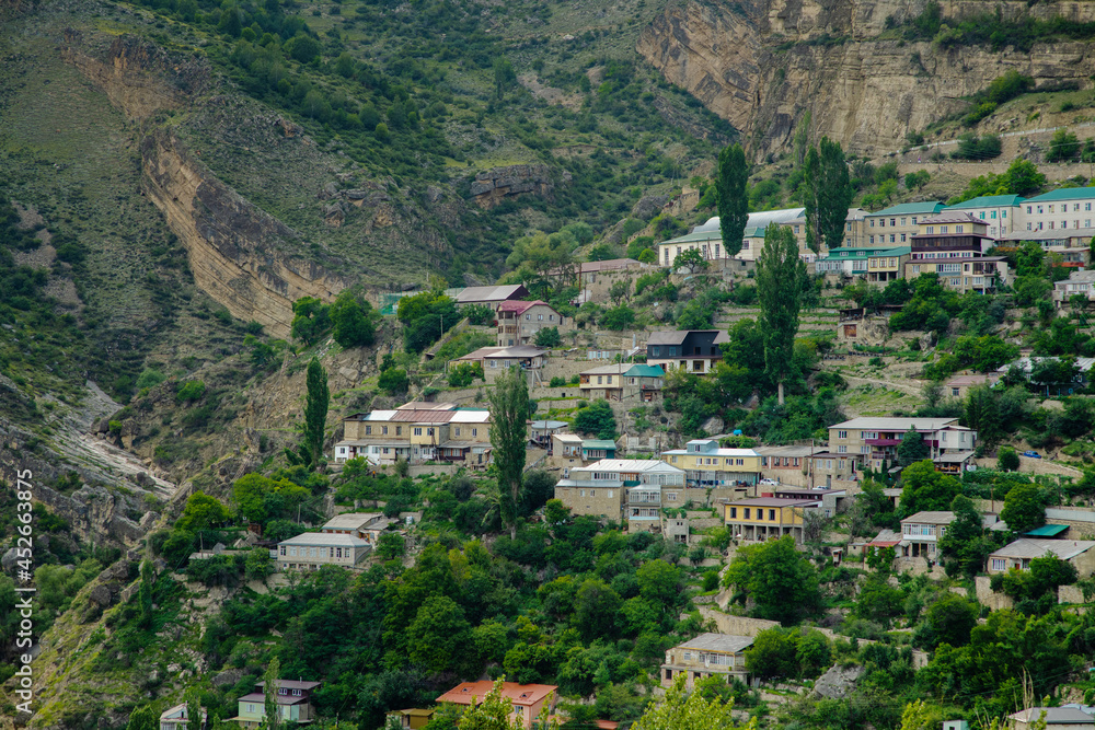 Settlement in the high mountains of Dagestan against the backdrop of the gorge. A city perched up a mountain of brown stone