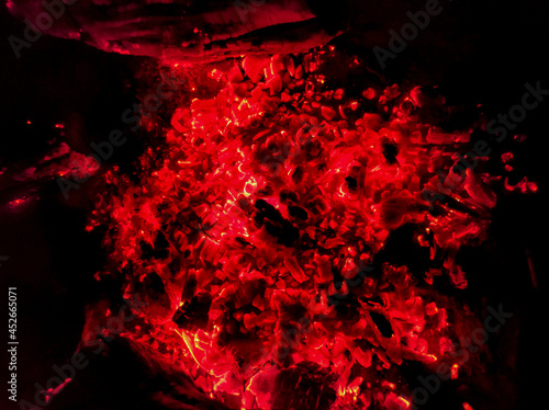 Red coals from a tree lie in a fire