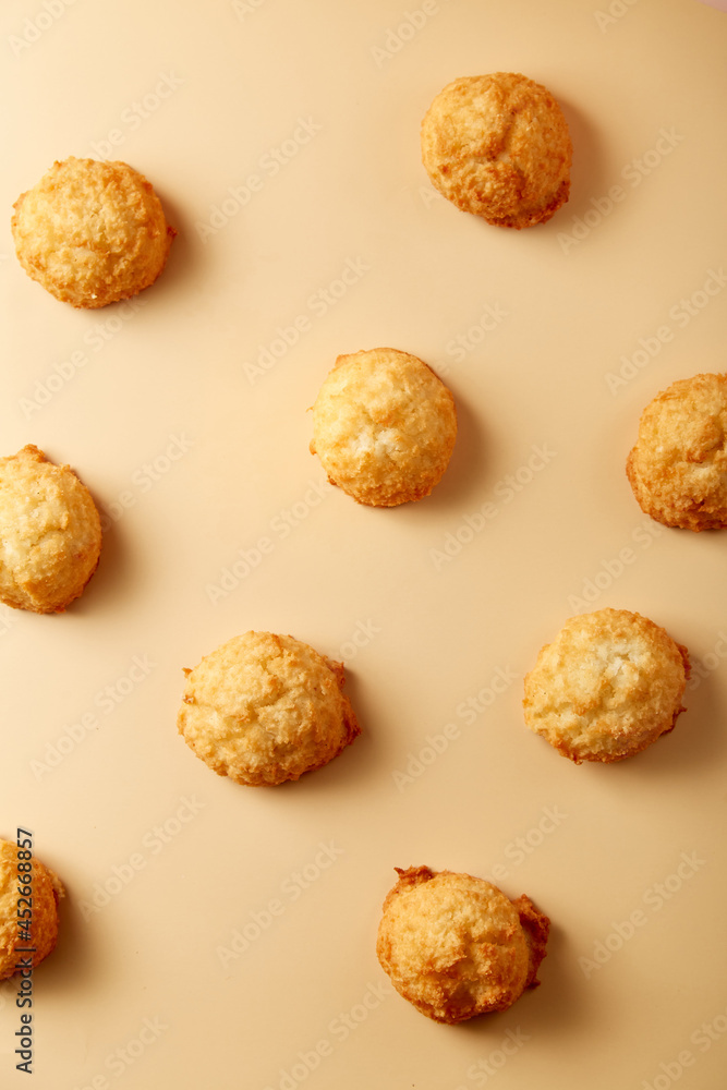 Toasted coconut cake arranged evenly on beige pastel background. Creative layout. Top view, flatlay. Nobody. Soft lighting Toasted coconut cake arranged evenly on beige pastel background. Creative layout. Top view, flatlay. Nobody. Soft lighting